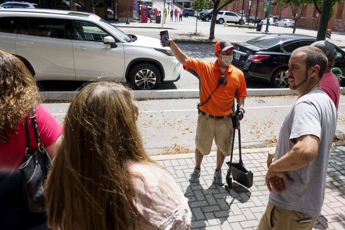 Staff photo by C.B. Schmelter / Downtown Chattanooga Alliance Director Steve Brookes, center, helps visitors along Broad Street on Saturday, Aug. 1, 2020 in Chattanooga, Tenn.