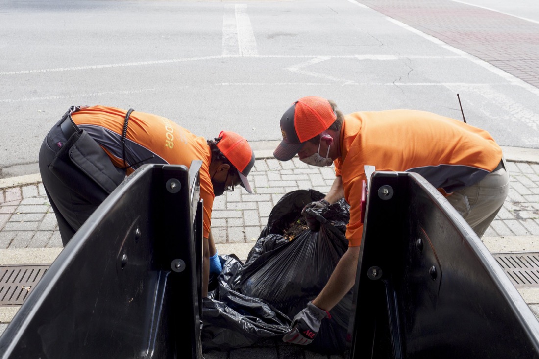 Staff photo by C.B. Schmelter / Downtown Chattanooga Alliance Team Leader Katrina Mason, left, and Director Steve Brookes work on double bagging a bag of trash along Broad Street on Saturday, Aug. 1, 2020 in Chattanooga, Tenn.