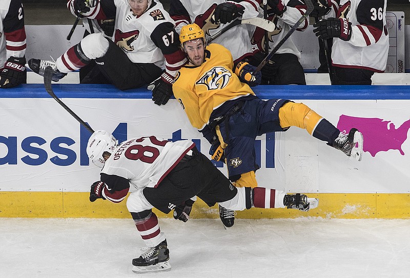 AP photo by Jason Franson / Nashville Predators center Kyle Turris (8) is checked into the boards by the Arizona Coyotes' Jordan Oesterle (82) during the first period of Sunday's NHL qualifying series matchup in Edmonton.