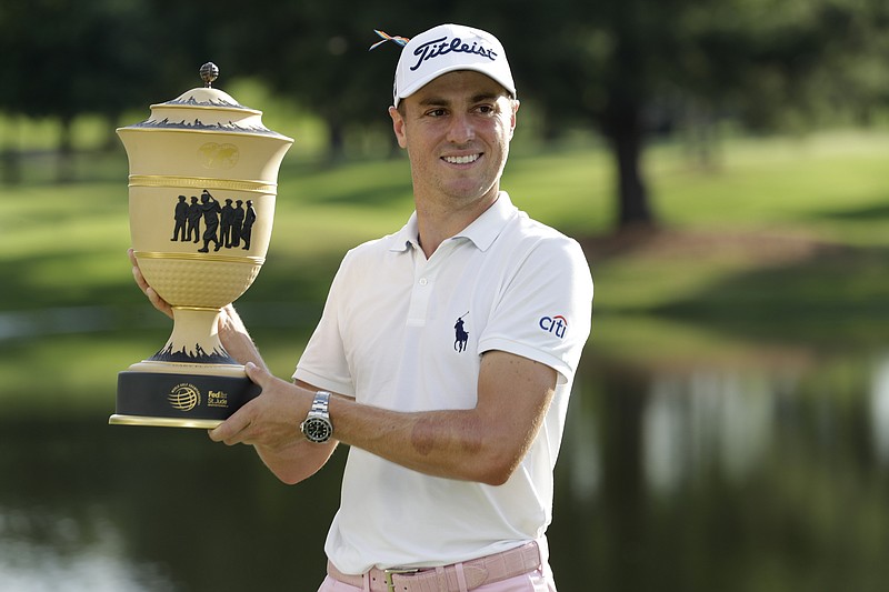 AP photo by Mark Humphrey / Justin Thomas holds the trophy after winning the FedEx St. Jude Invitational, a World Golf Championship, on Sunday at TPC Southwind in Memphis.