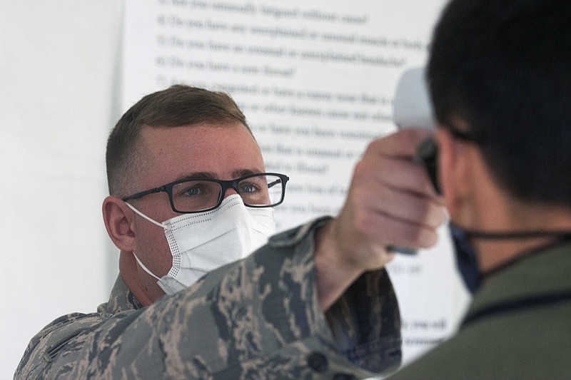 A member of the Nevada National Guard performs a temperature check during the second day of the 32nd Special Session of the Legislature, Saturday, Aug. 1, 2020 in Carson City, Nev.. (David Calvert/Nevada Independent via AP, Pool)