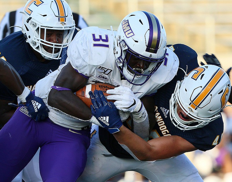 Staff photo / UTC's Ty Boeck, right, and Telvin Jones tackle James Madison's Percy Agyei-Obese on Aug. 21, 2019, at Finley Stadium.