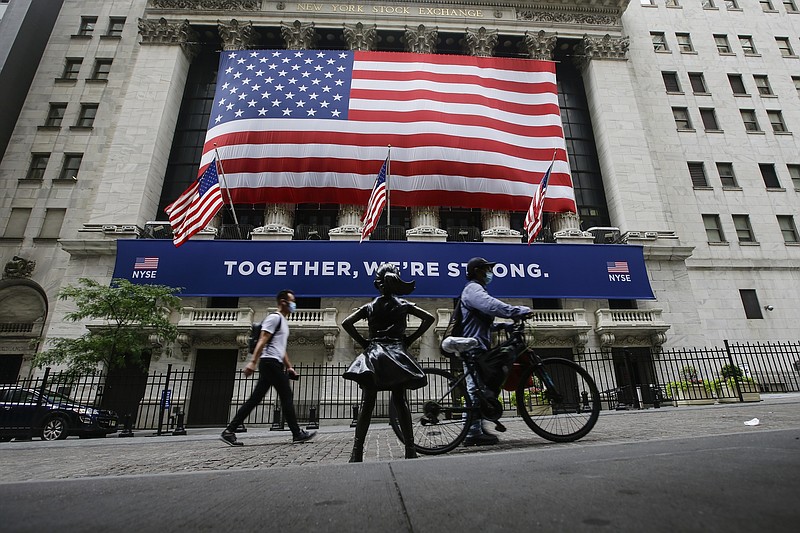 FILE - In this Tuesday, July 7, 2020 file photo, pedestrians wearing protective masks during the coronavirus pandemic pass by the New York Stock Exchange in New York. Wall Street is starting August with more gains, and U.S. stocks are climbing in early Monday, Aug. 3, 2020 trading following encouraging reports from around the world on the economy. (AP Photo/Frank Franklin II, File)