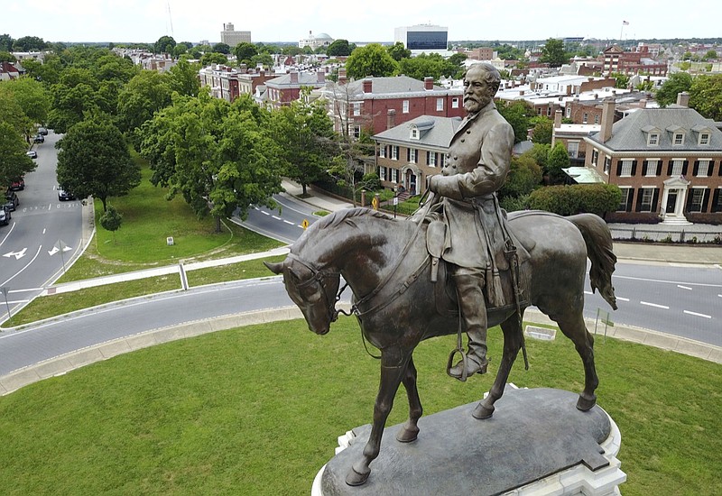 FILE - This Tuesday June 27, 2017, file photo shows the statue of Confederate General Robert E. Lee that stands in the middle of a traffic circle on Monument Avenue in Richmond, Va. A Virginia judge on Monday, Aug. 3, 2020 dissolved one injunction but imposed another preventing Virginia's governor from removing an enormous statue of Confederate Gen. Robert E. Lee. (AP Photo/Steve Helber, File)
