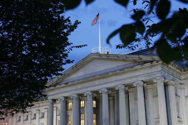 File-This Thursday, June 6, 2019, photo shows the U.S. Treasury Department building at dusk, in Washington. The Treasury Department is projecting government borrowing of $947 billion in the current July-September period, which would be a record for the quarter but down from the all-time high of $2.75 trillion in this year's second quarter. Treasury officials announced Monday, Aug. 3, 2020, that the government also plans to borrow $1.22 trillion in the October-December period. (AP Photo/Patrick Semansky, File)