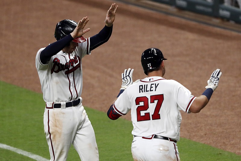 AP photo by John Bazemore / The Atlanta Braves' Austin Riley celebrates with teammate Freddie Freeman without contact after hitting a three-run home run in the fifth inning of Tuesday night's home game against the Toronto Blue Jays.