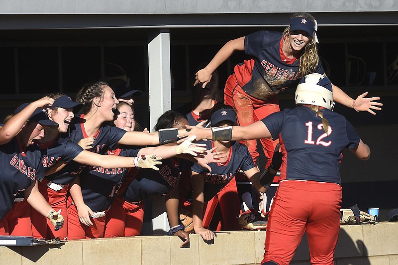 Staff photo by Robin Rudd / Carmen Gayler (12) is congratulated by her Heritage teammates in the dugout after she scored a run against visiting Marist on Oct. 28, 2019, in the GHSA Class AAAA state championship matchup.