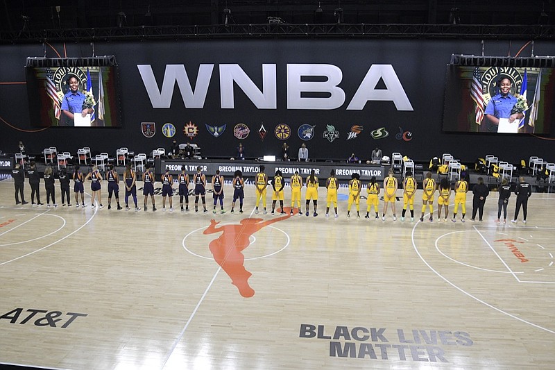 Members of the Phoenix Mercury, left, and Los Angeles Sparks stand for a moment of silence in honor of Breonna Taylor before a WNBA basketball game, Saturday, July 25, 2020, in Ellenton, Fla. (AP Photo/Phelan M. Ebenhack)