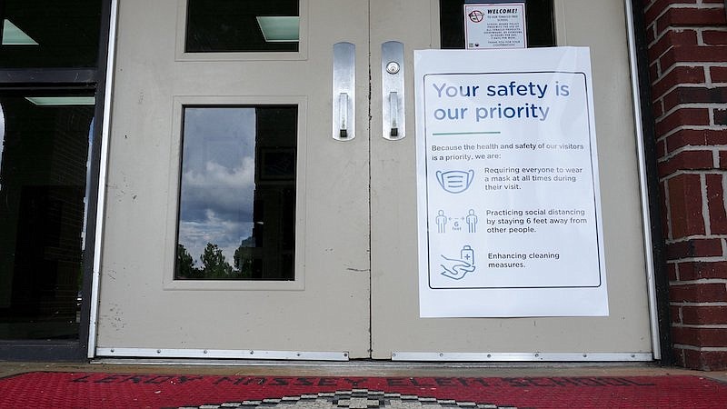 A sign outlining safety measures hangs on the door at Leroy Massey Elementary School on Tuesday, July 28, 2020, in Summerville, Ga. Thursday is the first day of school for over 2,600 students in the Chattooga County Schools system. As other districts around the state delayed their back-to-school days or moved to all-remote learning, Chattooga County school officials are going ahead with its plan to start school Thursday, one of the earliest start days in the nation. (C.B. Schmelter/Chattanooga Times Free Press via AP)