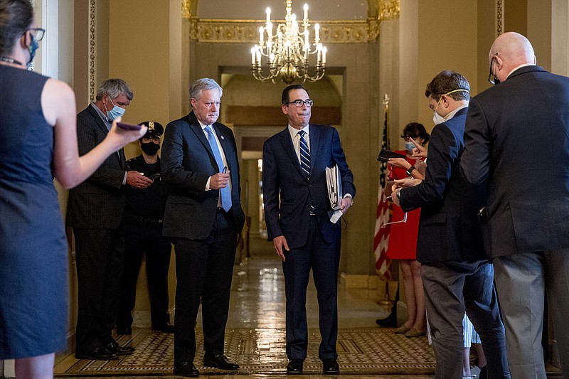 Treasury Secretary Steven Mnuchin, right, accompanied by White House chief of staff Mark Meadows, left, take a question from a reporter following a meeting with Senate Majority Leader Mitch McConnell of Ky. as negotiations continue on a coronavirus relief package on Capitol Hill in Washington, Tuesday, Aug. 4, 2020. (AP Photo/Andrew Harnik)