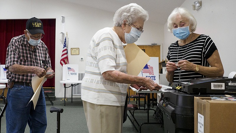 Staff photo by C.B. Schmelter / Alice Leiws, center, casts her ballot at Red Bank Cumberland Presbyterian Church on Thursday, Aug. 6, 2020, in Red Bank, Tenn.