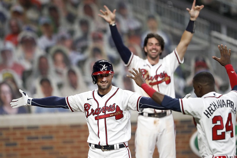AP photo by John Bazemore / The Atlanta Braves' Nick Markakis, left, celebrates with teammate Adeiny Hechavarria (24) after hitting the winning home run in the ninth inning of Thursday night's home game against the Toronto Blue Jays.
