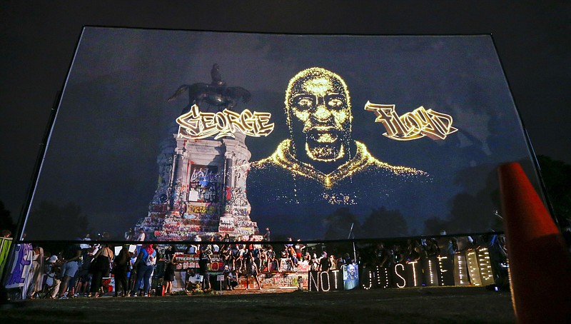 An image of George Floyd is projected on a screen in front of the statue of Confederate General Robert E. Lee on Monument Avenue Tuesday July 28, 2020, in Richmond, Va. Change.org and the George Floyd Foundation officially launched "A Monumental Change: The George Floyd Hologram Memorial Project" in Richmond, the capital of the Confederacy (AP Photo/Steve Helber)


