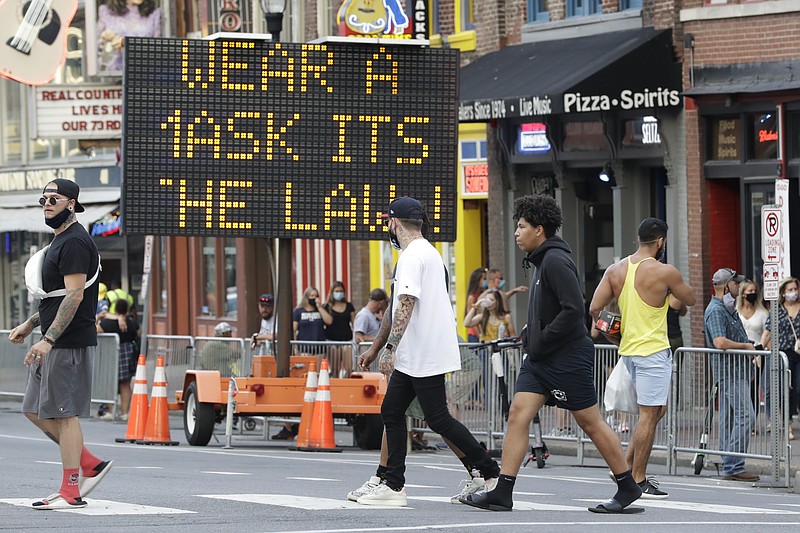 A sign encouraging the wearing of masks stands in downtown Nashville, Tenn., Wednesday, Aug. 5, 2020. The wearing of face coverings is required in most public indoor and outdoor situations in Nashville due to an increase of COVID-19 cases. (AP Photo/Mark Humphrey)


