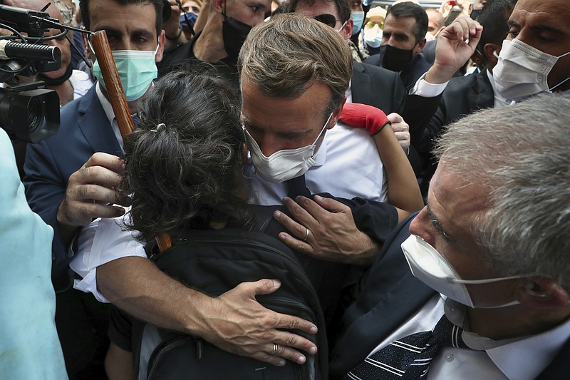 French President Emmanuel Macron, hugs a woman as he visits the Gemayzeh neighborhood, which suffered extensive damage from an explosion on Tuesday that hit the seaport of Beirut, Lebanon, Thursday, Aug. 6, 2020. (AP Photo/Bilal Hussein)