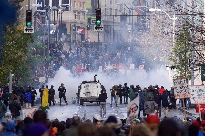 FILE - In this Nov. 30, 1999, file photo, Seattle police use tear gas to push back World Trade Organization protesters in downtown Seattle. The Associated Press found that there is no government oversight of the manufacture and use of tear gas. Instead, the industry is left to regulate itself. (AP Photo/Eric Draper, File)