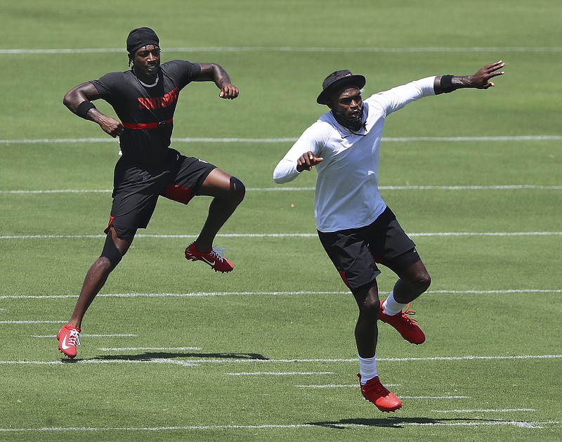 AP photo by Curtis Compton / Atlanta Falcons wide receivers Calvin Ridley, left, and Julio Jones go through a drill Tuesday at the team's training camp in Flowery Branch, Ga.