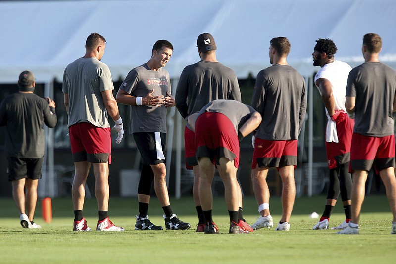 AP photo by Douglas R. Clifford / Tampa Bay Buccaneers quarterback Tom Brady, third from left, joins his teammates at midfield during training camp Tuesday in Tampa, Fla.