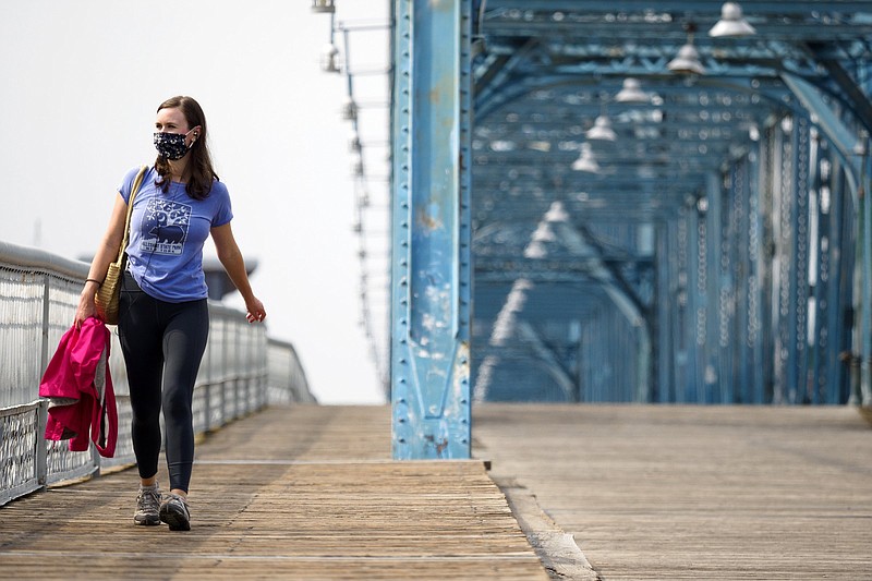 Staff photo by C.B. Schmelter / Lindsay Blum crosses the Walnut Street Bridge on Thursday, Aug. 6, 2020 in Chattanooga, Tenn. Blum, from Houston, Texas, was visiting because her husband had a job interview.