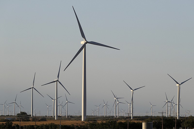 Wind turbines are seen on a rural road off of Interstate 20, Wednesday, July 29, 2020, near Sweetwater, Texas. (AP Photo/Tony Gutierrez)