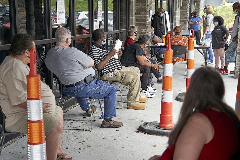 In this July 15, 2020, file photo, job seekers exercise social distancing as they wait to be called into the Heartland Workforce Solutions office in Omaha, Neb. The extra $600 in weekly unemployment benefits has expired, the federal eviction moratorium has ended and federal money to help businesses retain workers has grown lean. Meanwhile, the pandemic rages on and there is no consensus from Washington on another relief package. (AP Photo/Nati Harnik, File)