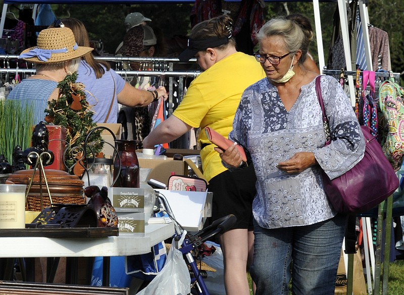 A crowd looks through items at the World's Longest Yard Sale, which stretches from Alabama to Michigan, at its southernmost point in Gadsden, Ala., on Thursday, Aug. 6, 2020. Promoters considered canceling the four-day sale because of the coronavirus pandemic but decided to go ahead with the event, now in its 34th year.   (AP Photo/Jay Reeves)