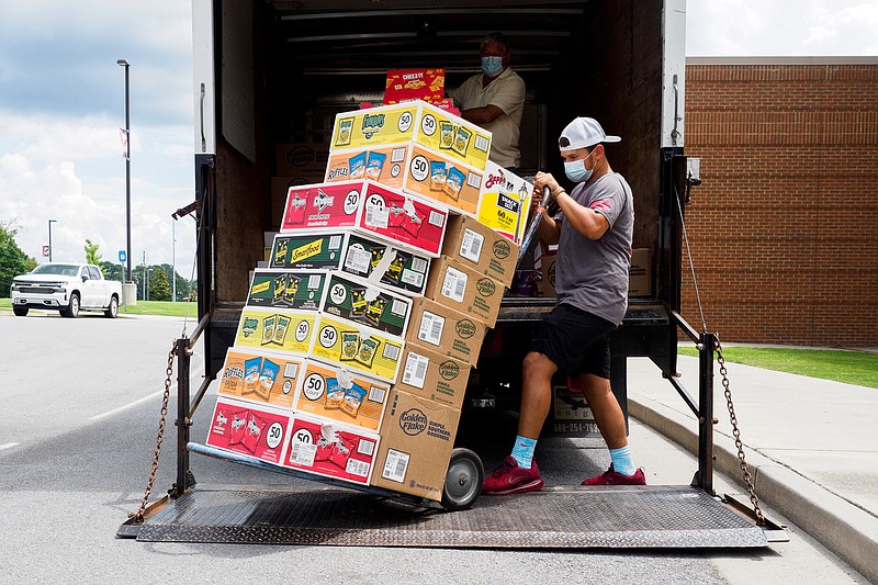 Staff photo by C.B. Schmelter / Vernon Smith, back, and Pacey Smith deliver snacks for the vending machines at Chattooga County High School on Tuesday, July 28, 2020 in Summerville, Ga.