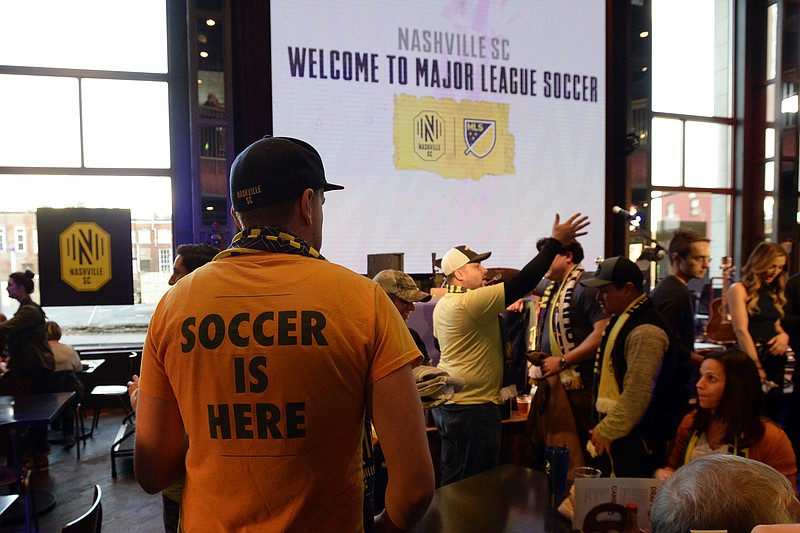 AP photo by Mark Zaleski / A Nashville SC fan looks for a seat before the start of the Major League Soccer expansion draft on Nov. 19, 2019, in Nashville. One of two expansion clubs for the MLS 25th anniversary season along with Inter Miami CF, Nashville has played just twice this year and had to miss the MLS is Back Tournament in Florida due to COVID-19 cases.