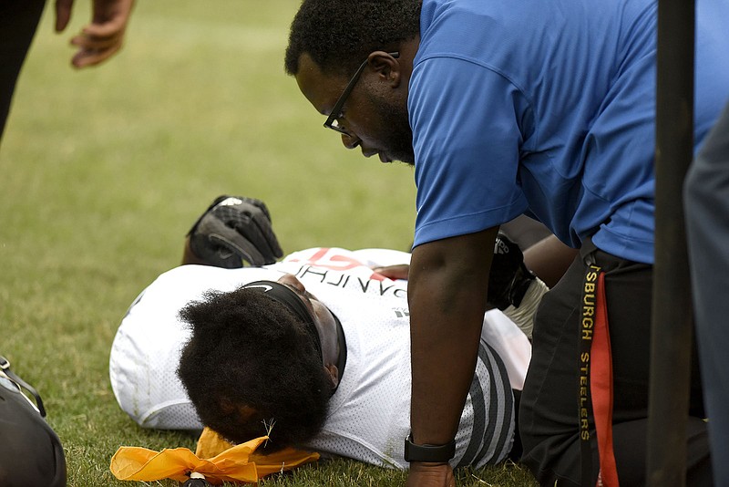Staff photo by Robin Rudd / A trainer attends to an injured Brainerd football player during a game at Howard on Aug. 17, 2018. is seen to by the trainer as the player's head rest on a penalty flag. Erlanger Sports and Health Institute supplies licensed athletic trainers to 14 public high schools in Hamilton County, as well as three in Georgia.