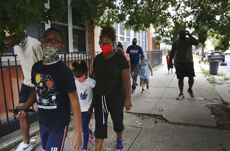 St. Francis Xavier School students and their families walk together in Newark, on Thursday, Aug. 6, 2020, after discussing the Catholic school's permanent closure announced the previous week by the Archdiocese of Newark. Nationwide, more than 140 Catholic schools will not reopen in the fall. (AP Photo/Jessie Wardarski)