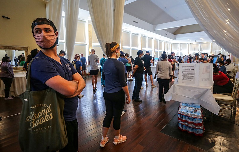 Voters wait in line to cast their ballots in the state's primary election at a polling place, Tuesday, June 9, 2020, in Atlanta, Ga. Some voting machines went dark and voters were left standing in long lines in humid weather as the waiting game played out. (AP Photo/Ron Harris)