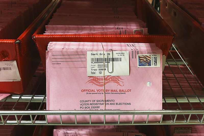 Photo by Rich Pedroncelli of The Associated Press / In this Oct. 22, 2018, file photo, mail-in ballots are placed in bins to be processed after arriving at the Sacramento County Registrar of Voters in Sacramento, California. Over 100,000 mail-in ballots were rejected by election officials in California's March presidential primary, highlighting a glaring gap in the effort to ensure every vote is counted as a national dispute rages over the integrity of vote-by-mail elections.