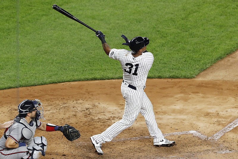 AP photo by Kathy Willens / Atlanta Braves catcher Travis d'Arnaud, left, watches as the New York Yankees Aaron Hicks follows through on a run-scoring double in the fourth inning of Wednesday night's game in New York.