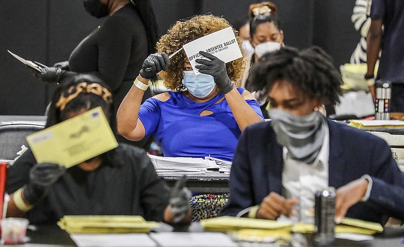 Election officials sort absentee ballots, Tuesday, Aug. 11, 2020, in Atlanta. Voters in Georgia return to the polls Tuesday for runoffs to settle party nominations in four congressional races and 17 legislative races, as well as a closely watched contest for who will claim the Democratic nod for district attorney in Fulton County. (John Spink/Atlanta Journal and Constitution via AP)