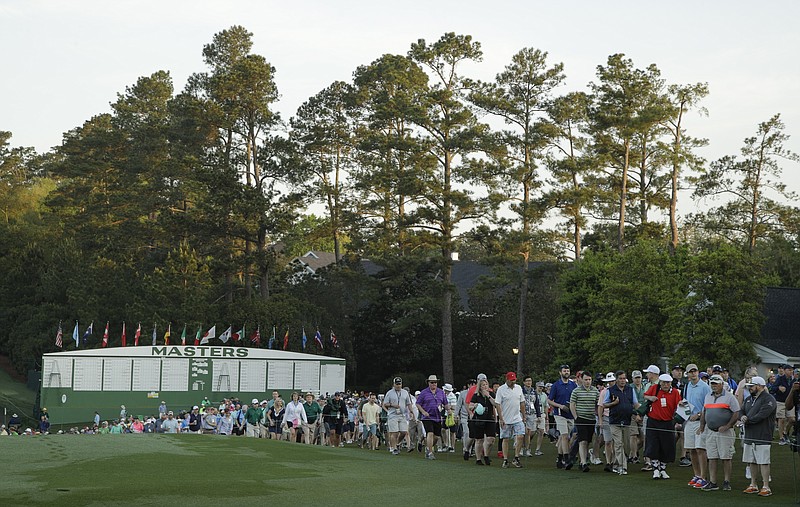 AP photo by Charlie Riedel / Fans walk along the first hole at Augusta National Golf Club on April 11, 2019, during the opening round of the Masters. The Georgia club announced Wednesday that it will not permit spectators when its hosts its annual major championship tournament, which was already moved from April to November because of the COVID-19 pandemic.