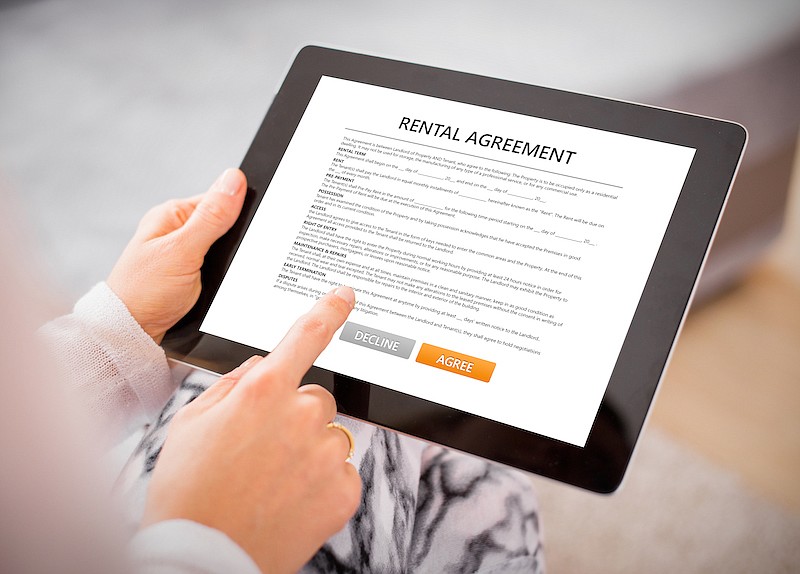 Woman reading rental agreement on tablet. Photo credit: Getty Images/iStock/grinvalds