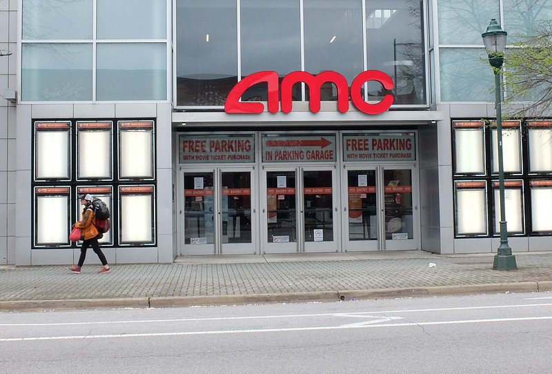 Staff photo by Tim Barber/ Loaded with pounds of personal belongings, a lone walker passes the blank poster frames of the AMC movies theater in the 300 block of Broad Street Saturday afternoon, Mar. 21, 2020, in downtown Chattanooga.