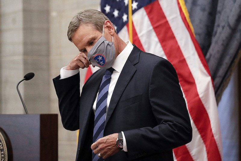 In this July 1, 2020, file photo, Tennessee Gov. Bill Lee removes his mask as he begins a news conference in Nashville, Tenn. Tennessee was one of the first states to begin reopening in late April after Lee reluctantly issued a safer-at-home order that forced businesses to close. Since then, case numbers have continued to rise in part due to more testing, but also because of an increase in community spread of the disease. (AP Photo/Mark Humphrey, File)