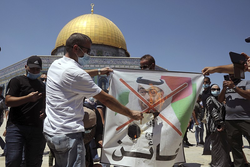 Palestinian protesters burn a banner showing Abu Dhabi Crown Prince Mohamed bin Zayed al-Nahyan during a protest against the United Arab Emirates' deal with Israel near the Dome of the Rock Mosque in the Al Aqsa Mosque compound in Jerusalem's old city on Friday.
