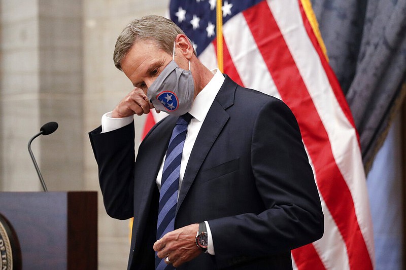 FILE - In this July 1, 2020, file photo, Tennessee Gov. Bill Lee removes his mask as he begins a news conference in Nashville, Tenn. (AP Photo/Mark Humphrey, File)