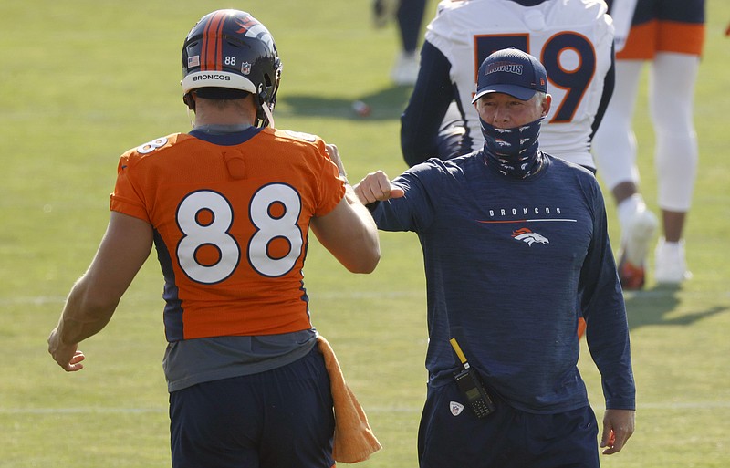 AP photo by David Zalubowski / Denver Broncos tight end Nick Vannett, left, greets offensive coordinator Pat Shurmur on Friday during training camp in Englewood, Colo.