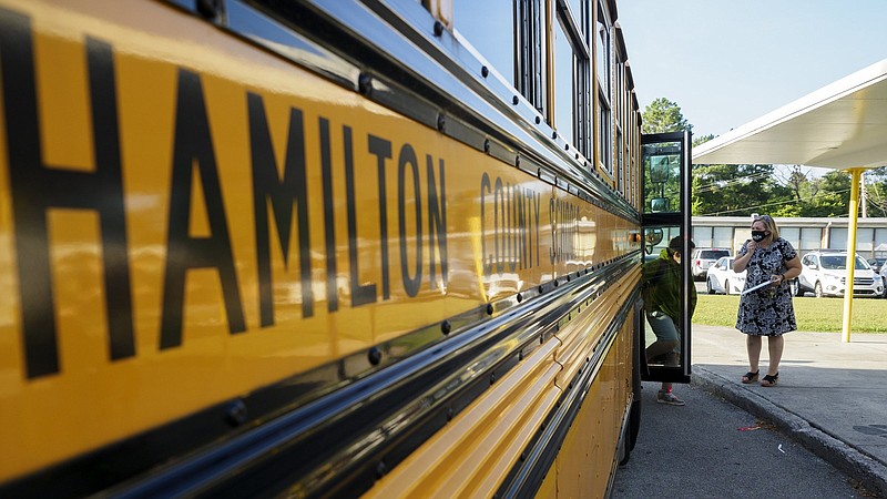 Staff photo by C.B. Schmelter / Assistant Principal Jennifer Rodgers helps direct as a student gets off of a bus on the first day of school at Hixson Elementary School on Wednesday, Aug. 12, 2020 in Hixson, Tenn.