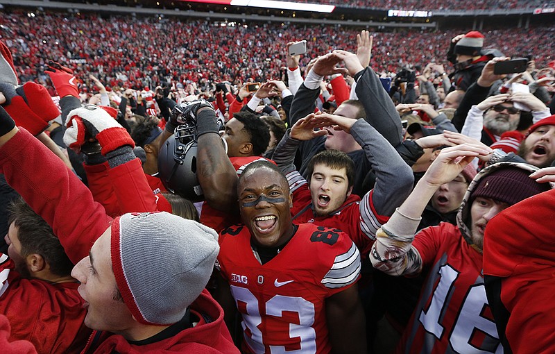 AP photo by Jay LaPrete / Ohio State football players and fans celebrate a 30-27 double-overtime win over visiting Michigan on Nov. 26, 2016, in Columbus, Ohio.