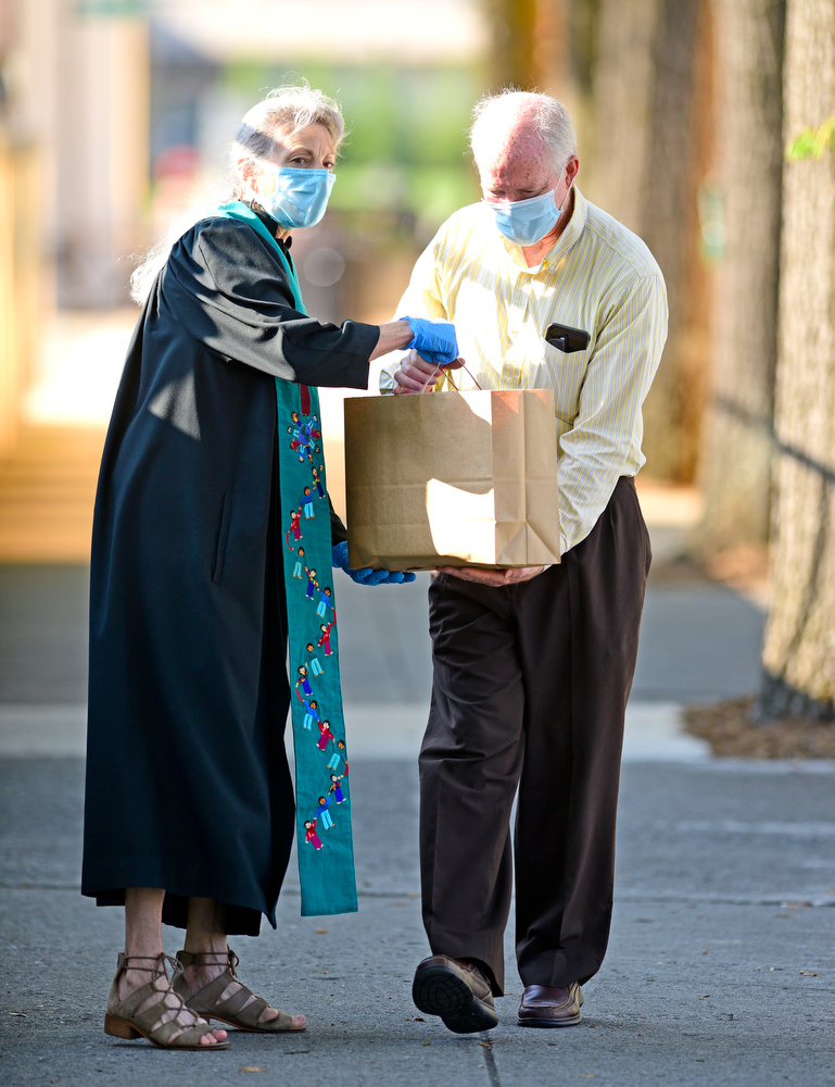 Staff Photo by Robin Rudd / Pastor Cathy Meyers hands off a bag of donated food to her husband, Ken. Second Presbyterian, on Pine Street held a Drive By Communion on August 16, 2020. This was the first ever for the event and gave church members a chance to see each other since the onset of the COVID-19 pandemic. The church also collected non perishable food items and back to school supplies.