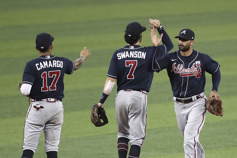 AP photo by Lynne Sladky / From left, the Atlanta Braves' Johan Camargo, Dansby Swanson and Nick Markakis, right, congratulate one another after a 4-0 win against the host Miami Marlins on Sunday afternoon. The Braves gained ground on first-place Miami in the NL East standings.