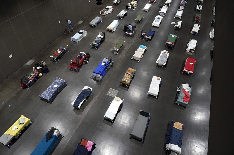 Beds fill a homeless shelter inside the San Diego Convention Center Tuesday, Aug. 11, 2020, in San Diego. When the coronavirus emerged in the United States this year, public health officials and advocates for the homeless feared the virus would rip through shelters and tent encampments, ravaging vulnerable people who often have chronic health issues. Yet, the virus so far does not appear to have brought devastation to the homeless population as many feared. (AP Photo/Gregory Bull)