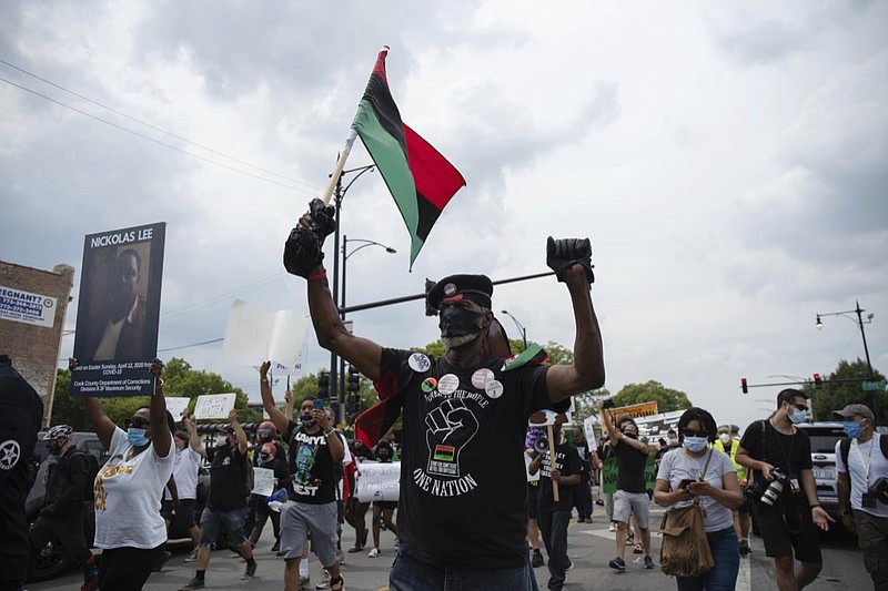 About 200 anti-police brutality protesters march in the neighborhood of Bronzeville, in Chicago, Saturday, Aug. 15, 2020. Protesters walked from Bronzeville to Grant Park, after police prohibited them from marching along the Dan Ryan Expressway. (Pat Nabong/Chicago Sun-Times via AP)