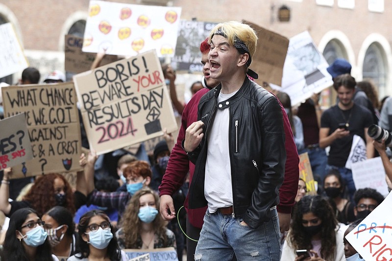 People take part in a protest outside the Department for Education, London, Sunday Aug. 16, 2020, in response to the A-level results. The British government has been urged to "get a grip" over how grades are being awarded to school students, who were unable to take exams earlier this summer because of the coronavirus pandemic. The latest confusion emerged late Saturday when England's exam regulator launched a review on its own just-published guidance on how students can appeal grades awarded under a complicated system. (Jonathan Brady/PA via AP)