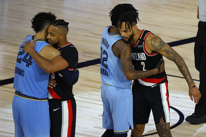AP photo by Kevin C. Cox / The Portland Trail Blazers' Gary Trent Jr., far right, hugs Memphis Grizzlies rookie Ja Morant while Portland's CJ McCollum hugs the Grizzlies' Dillon Brooks after their play-in game for the NBA postseason Saturday in Lake Buena Vista, Fla. The Grizzlies, who needed to beat the Blazers twice, were eliminated when Portland won.