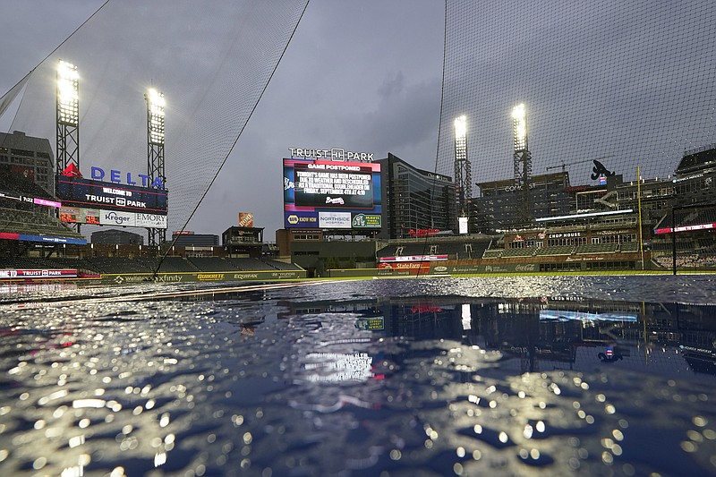AP photo by John Bazemore / A sign behind the center field wall at Truist Park displays a message announcing that Wednesday's game between the host Atlanta Braves and the Washington Nationals was postponed because of rain.